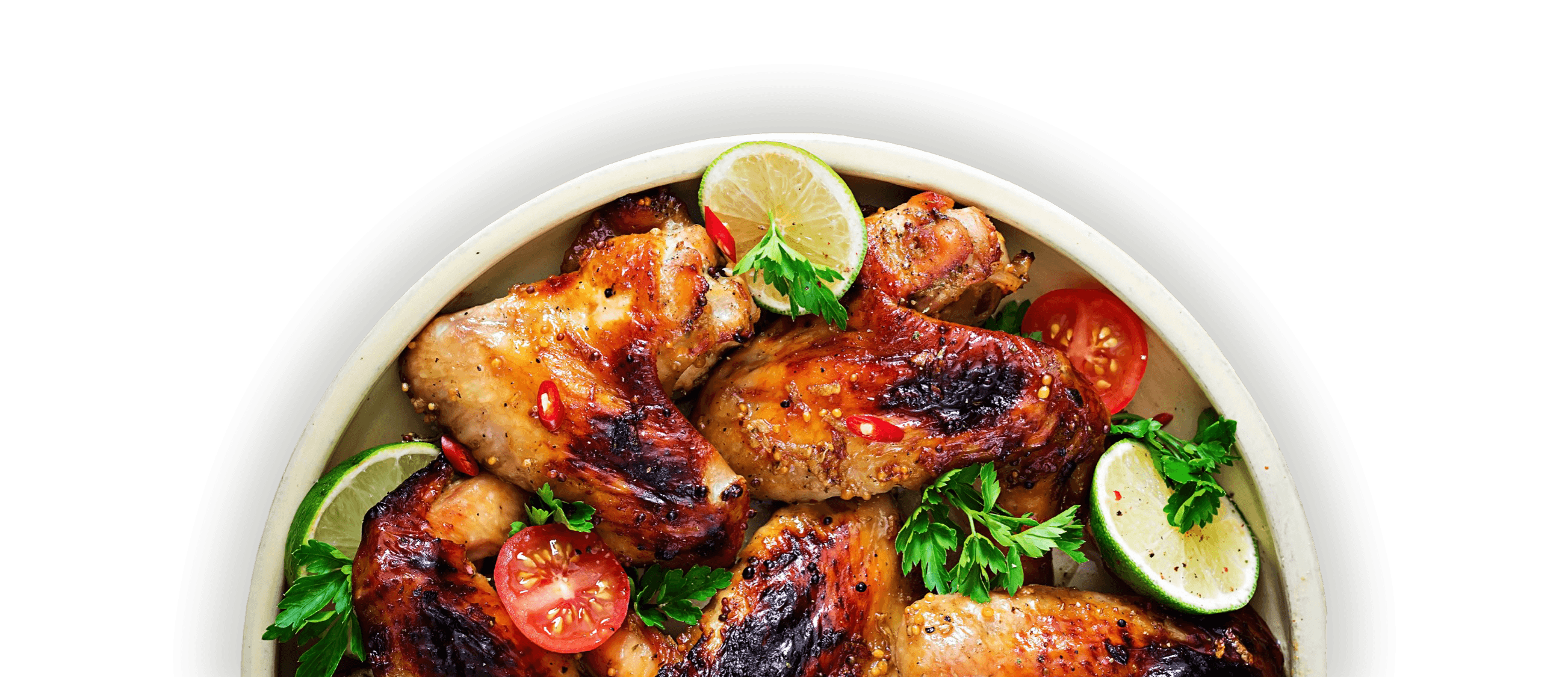 A roasted chicken dish mixed with tomatoes, limes, and parsley in a recyclable bowl