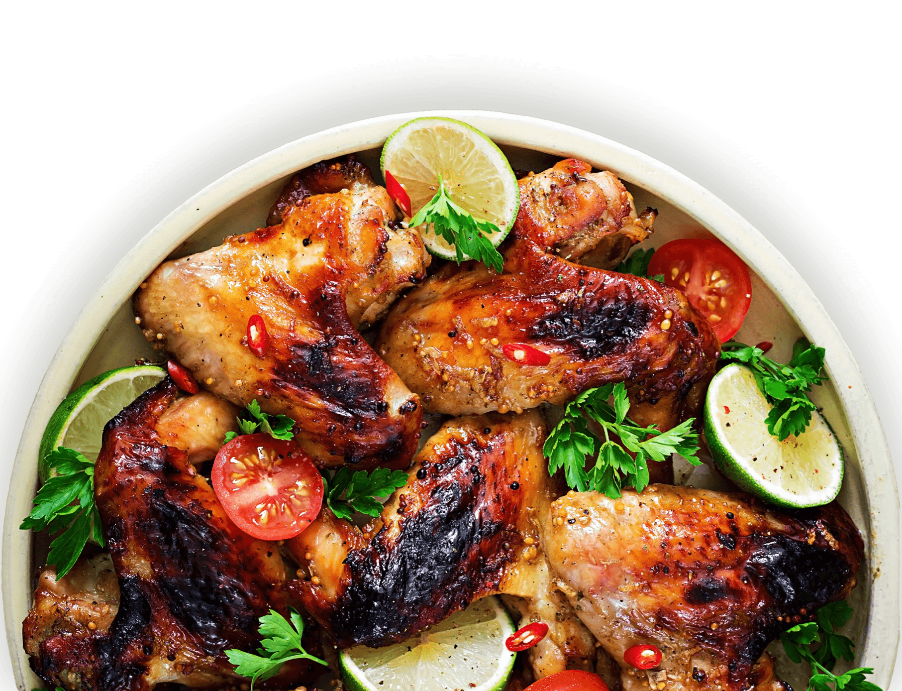 A roasted chicken dish mixed with tomatoes, limes, and parsley in a recyclable bowl